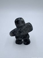 Front view of dark grey Inuit stone carving figurine