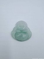 Front view of carved jade laughing Buddha pendant