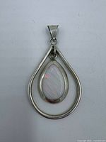 Front view of sterling silver pendant showing opal cabochon and teardrop frame