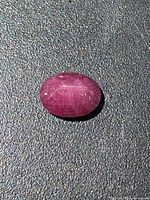 Top view of oval cabochon ruby showing overall color and surface features