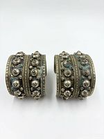 Front view of both silver cuff bracelets showing raised dome decorations