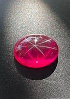 Close-up of oval cabochon star ruby showing six-ray star