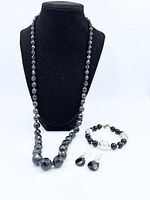 Full view of necklace, bracelet and earrings set on display bust