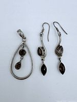 Pendant and pair of earrings laid flat