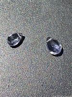 Two loose faceted gemstones on textured surface