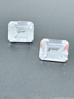 Top view of both rectangular white sapphires on dark background