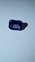Emerald-cut tanzanite gemstone on white background