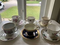 Six bone china teacup and saucer sets displayed