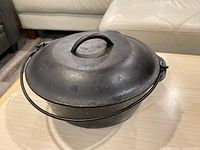 Side view of cast iron dutch oven with lid and bail handle