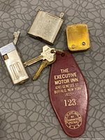 Overall lot view: key fob with keys, two lighters, brass box