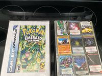 Pokémon Emerald GBA box next to binder page of cards