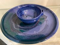 Plate with handled bowl displayed on top, showing glaze colors
