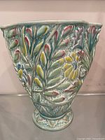 front view showing floral relief design and pedestal base