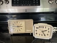Both alarm clocks together on stovetop
