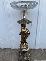 Full view of pedestal ashtray showing ornate base, cherub column, crystal prisms, glass dish