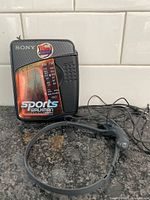 Front view of Sony Sports Walkman with headphones coiled beside unit