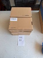Stack of 10 brown cardboard boxes labeled POWER BANK on a table.