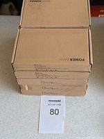 Stack of five brown cardboard boxes labeled Power Bank, showing original packaging for the power banks.