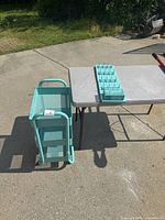 Three-tier aqua cart on wheels viewed from the side and top.