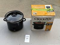 Photo of the Crock-Pot slow cooker next to its original box on a table showing the device and packaging