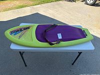 Top view of the green and purple kneeboard showing the padded area and adjustable strap