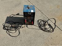 Front view of Miller Thunderbolt 225 welder with attached cables
