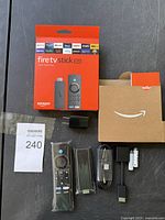 Full lot display with box, remote, stick, power adapter, HDMI extender, USB cable, and Amazon box.