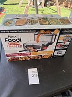 Front view of unopened box showing product features and images of toaster/oven usage.