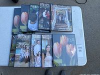 Ten black 8.5 x 11 photo frames laid out on a table, some still showing sample photos with family images and tulips, confirming size and style.