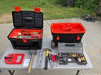 Overall display of toolbox and tools laid out on table including hammer, mallet, level, screwdrivers, garden bender and hardware organizer.