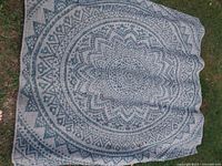 Top-down view of the full Safavieh outdoor carpet laid on grass showing the overall pattern and condition.
