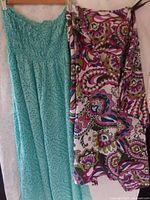 Photo showing aqua strapless maxi dress with smocked bodice and sequin details next to a multicolor paisley pattern beach cover-up by Land's End Canvas
