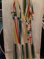 Front and full view of a vertically striped midi-length wrap dress in size L with colorful stripes and sleeve ties.