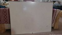 Front view of large whiteboard showing metal frame and visible surface marks.