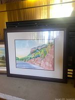 Full view of framed watercolour landscape painting by Andrew Durnfore showing the road, rocky cliffs, and greenery.