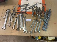 Overview of wrenches, Vice-Grips and wrench racks on table.