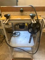 Front view of the Mastercraft router table on metal stand with power cord and adjustable knobs.