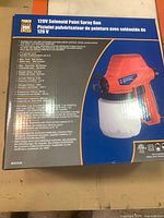 Box front showing Powerfist 120V solenoid paint spray gun image and features in English and French