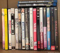 Row of DVD cases showing titles such as Invictus, City Hall, Rudy, Nine Months, In Search of Ancient Ireland, Exploring the Da Vinci Code, Evelyn and For the Boys