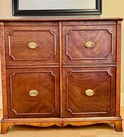 front view of cabinet closed showing four panel design and brass pulls