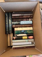 Box containing 31 hardcover novels, spines showing several identifiable titles