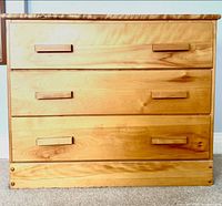 Front view of pine chest showing three drawers and wooden pulls