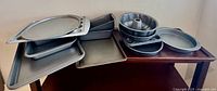 Stacked aluminum baking sheets, loaf, pizza, muffin, cake and Bundt pans