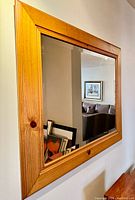 Front angled view of rectangular pine framed mirror on wall