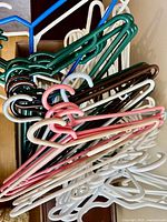 Bundle of assorted colour plastic hangers in a box