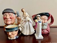 Group image of two figurines and three toby jugs