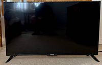 Front view of Westinghouse 50-inch TV on carpet showing screen and stand feet