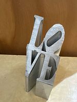Front angle showing brushed aluminum LOVE sculpture
