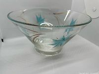 Overall view of flared clear glass bowl, turquoise starburst motif visible