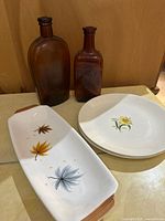 Group shot of two amber bottles, oblong platter, two plates